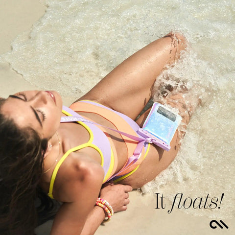 Person lounging on the beach with IP68 Waterproof Phone Pouch With Floating Lock Seal In Iridescent Soap Bubble Finish in water.