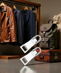 Two Pack Zipper Pull Replacement Kit Universal Zipper Slider Tabs For Luggage Backpacks Jackets Suitcases Coats And Sewing Notions Easy Repair Durable Silver shown beside luggage and clothing.