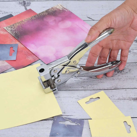 Hand using Heavy Duty T Slot Hole Punch Handheld Tool for ID cards, punching hole in yellow cardstock, silver zinc alloy, spring action.