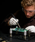 Person using a Magnetic Four Piece PCB Holder With Adjustable Arms Clamp Stand For Soldering Desoldering And Rework On Circuit Boards.