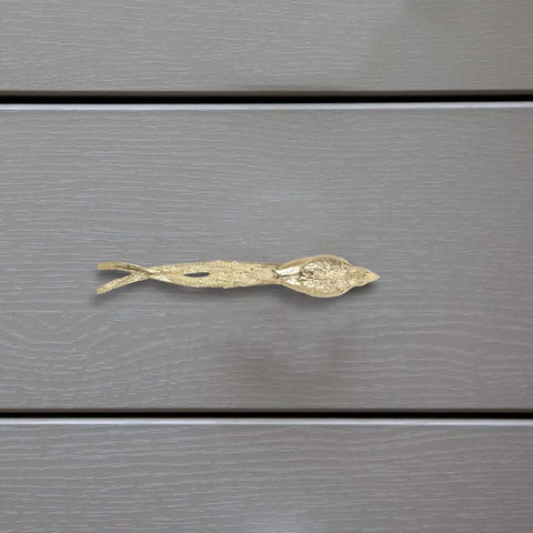 Dope Brass Bird Shape Cabinet Handles With Golden Finish, Sleek And Unique Design on gray wooden drawer