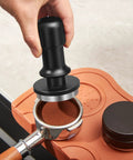 53mm Espresso Tamper With Auto Calibrated 30 LB Spring Loaded Stainless Steel Ground Tamper in use on portafilter