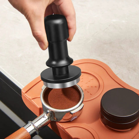53mm Espresso Tamper With Auto Calibrated 30 LB Spring Loaded Stainless Steel Ground Tamper in use on portafilter