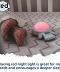 Calming Baby Sleep Aid With 6 Soothing Vibration Modes And Red Night Light next to baby feet on a crib mattress.