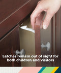 Bulletproof Spring Loaded Cabinet And Drawer Latches 10 Pack White being installed on a wooden cabinet for child safety.