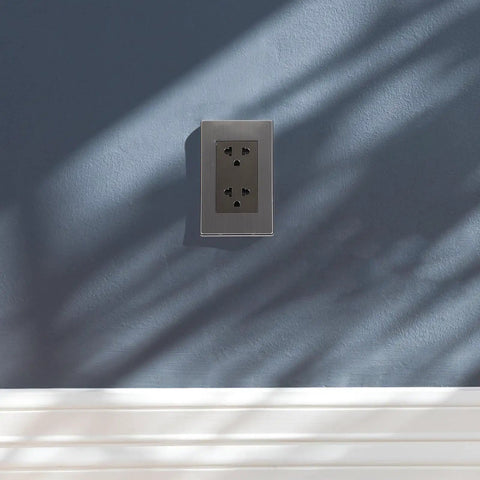Heavy-Duty 6-Hole Circular Wall Outlet Socket Cover In Rust-Free Stainless Steel on blue wall with shadows.