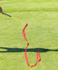 Golf Swing Trainer Stick With Comfortable Grip And Ribbon For Gesture Correction And Warm Up Practice in use on green grass