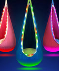 Light Up Pod Swing Seat For Kids With LED Lights, Sensory Hammock Chair in blue, pink, and red colors glowing against a dark background