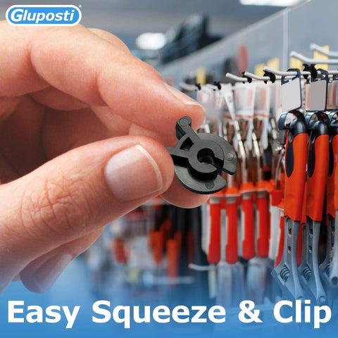 Hand holding black squeeze and pinch pegboard clip in retail display, Black Squeeze And Pinch Pegboard Clips For One Quarter Inch Pegboard And One Quarter Inch Slat Wall Hooks Pro Grade Lockdown Clips For Inventory Control That Secure Retail Hooks On Pegboard And Slat Wall Panels 100 Pack