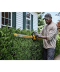Man using Badass Cordless Hedge Trimmer Equipped With 60 Volt Lithium Battery for bush trimming in yard.
