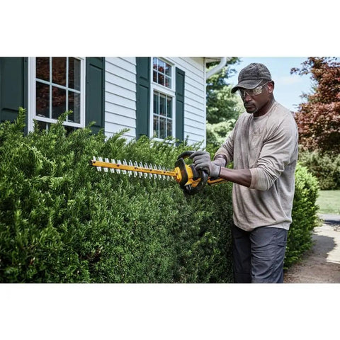 Man using Badass Cordless Hedge Trimmer Equipped With 60 Volt Lithium Battery for bush trimming in yard.