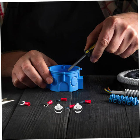 Close-up of hands using a screwdriver on a blue electrical junction box with connectors and components around.