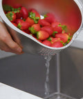 Stainless Steel Rice Washer Strainer Bowl With Agitator Bumps, rust-resistant colander rinsing strawberries over sink, meal prep