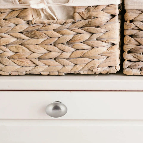 Smooth And Stylish Satin Nickel Mushroom Cabinet Knobs For No Sweat Hardware Swaps And Instant Kitchen Glow Ups That Fit Perfectly On Drawers Cupboards And Desk Surfaces on white drawer next to woven baskets.