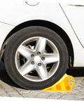 2 Pack Heavy Duty Rubber Wheel Chocks positioned under a car tire, showcasing sturdy hoist handles and grit treads.