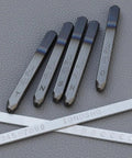 36 Piece Alphabet And Number Stamp Set With Built In Alignment Tools For Precise Imprinting On Metal Plastic And Wood One Eighth Inch 3mm Punch Hardened To HRC 62 With Durable Storage Box Made In USA, showing various letter and number punches.