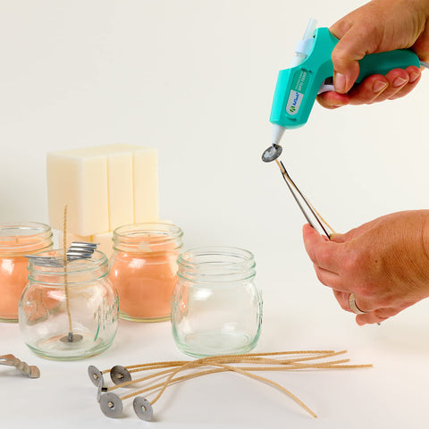 Hands using Clear Mini Hot Glue Sticks 4 Inch, 550 Count, All Temp Bonding for Crafting with mini glue gun and candle jars