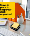 Pop-up sticky note dispenser with one 50-sheet canary yellow 3 in x 3 in pad, black base and clear lid desktop holder on desk