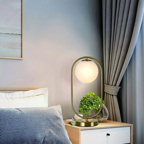 Gold Brass Finish Oval Bedside Table Lamp With Milky White Shade For Living Room And Bedroom Cozy Glow Soft Reading Light placed on a nightstand