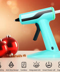 Cordless Hot Glue Gun Kit With Rechargeable Built In Battery Smart Auto Off 2Ah, Mini Glue Gun next to red holiday ornaments