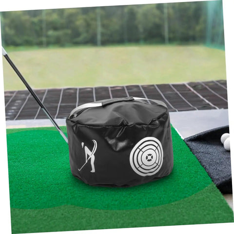 Portable Golf Impact Training Bag Swing Trainer for practice indoors or outdoors on green mat next to golf club and balls.