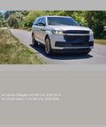 Silver Lincoln Navigator driven on scenic road with trees