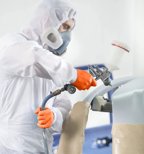 Worker using spray gun wearing Orange Lightning Gloves OR-L Large Work-Ready for industrial medical food service and general use.