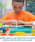 Child reading manual for Build Your Own Pinball Machine STEM Kit For Kids And Makers, Gumball Rally Edition, on table with parts