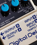 Close-up of digital delay guitar effects pedal with 11 modes, showing controls and input/output jacks for external footswitch use.