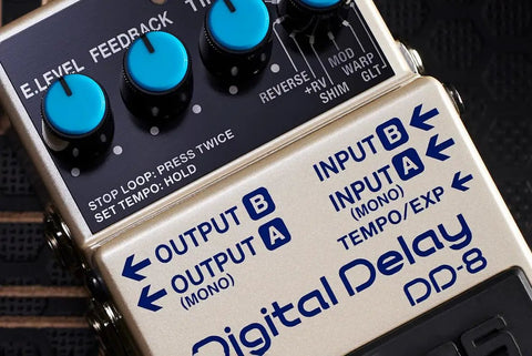 Close-up of digital delay guitar effects pedal with 11 modes, showing controls and input/output jacks for external footswitch use.