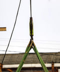 One Inch By Six Foot Flat Eye To Eye Lifting Sling in use, hoisting material, green polyester strap with heavy duty hooks outdoors