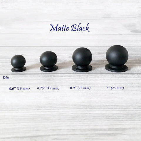 Four sizes of matte black ball knobs on wooden surface, including Solid Brass Matte Black Ball Knob For Cabinets And Drawers Go To Tiny 0.6 Inch Diameter 16 mm Vanity Knob Kitchen Hardware Small Drawer Pull Includes 1 Inch M4 Screw.