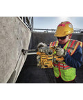 Worker using Onboard Dust Extractor for 1-1/8-Inch SDS Plus Rotary Hammers With Clear Dust Box and Replaceable Nozzle on concrete wall