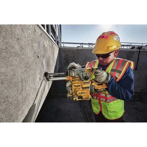 Worker using Onboard Dust Extractor for 1-1/8-Inch SDS Plus Rotary Hammers With Clear Dust Box and Replaceable Nozzle on concrete wall