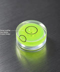 4Pcs Small Circular Bubble Levels, Double Sided Adhesive Bottom Mini with clear bubble view on a surface.
