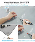 Hands soldering on a 30x24 Inch ESD Rubber Mat With Grounding Kit For PC Building And Electronics Repair Anti Static Table Pad.