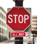 Stop sign with red background and white letters, featuring an all-way sign beneath for traffic control.