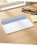 White Pro-Grade Self-Sealing Security Mailing Envelopes 115mm X 225mm with open flap on desk