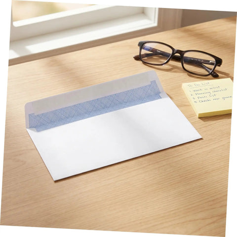 White Pro-Grade Self-Sealing Security Mailing Envelopes 115mm X 225mm with open flap on desk