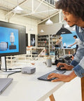 A man using a keyboard with a Top Shelf Thunderbolt Four Universal Type C Docking Station on a desk.