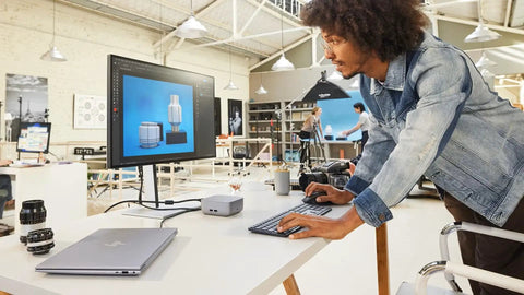 A man using a keyboard with a Top Shelf Thunderbolt Four Universal Type C Docking Station on a desk.