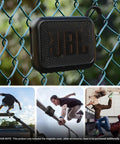 Magnetic Shockproof Case For JBL GO 4 Speaker Liquid Silicone Cover hanging on a fence, showcasing outdoor durability.