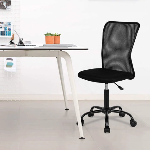 Go-To Ergonomic Mesh Office Chair With Lumbar Support Mid Back Armless Desk Chair beside a desk in a modern office