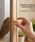 Close-up of a hand using a 30mm gold knob on a wooden cabinet, labeled 'Gold Cabinet Knobs Bulk Pack 50 Pcs 1-1/6 Inch 30mm Drawer Pulls'.