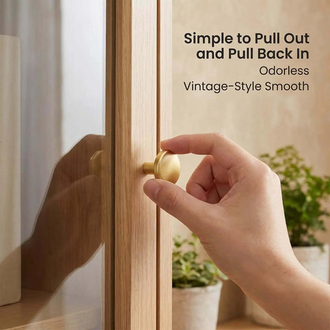 Close-up of a hand using a 30mm gold knob on a wooden cabinet, labeled 'Gold Cabinet Knobs Bulk Pack 50 Pcs 1-1/6 Inch 30mm Drawer Pulls'.