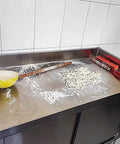 Heavy Duty Stainless Steel Prep Table With Cabinet And Splash Guard Slick Commercial Kitchen Workbench Built Like A Tank For Restaurants Or Garages Double Sliding Doors Makes Cleanup A Breeze, showing flour and tools on the surface.