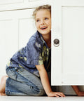 Child playing near cabinet with Set Of 2 Chinese Style Tiger Head Cabinet Handles in Antique Copper on white door.
