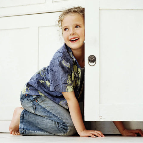 Child playing near cabinet with Set Of 2 Chinese Style Tiger Head Cabinet Handles in Antique Copper on white door.