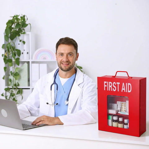 Doctor sitting at desk with red first aid kit, stethoscope around neck, beside Wall Mount First Aid Cabinet With Three Shelves.