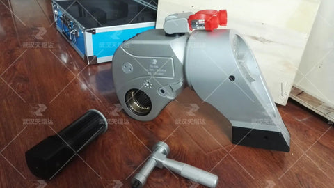 Top Shelf Hydraulic Torque Wrench With 1 1/2 Inch Drive showing assembly and accessories on wooden surface.